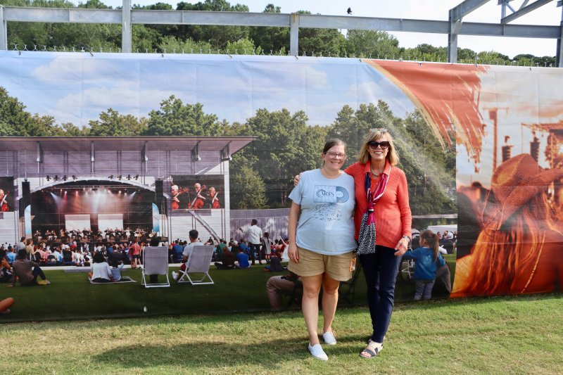 Alyson Cunningham, Joshua M. Freeman Foundation marketing manager, left, and Patti Grimes, Joshua M. Freeman Foundation executive director, stand in front of a rendering of the new stage. Grimes said the larger stage will help them book performers who need more room. But, she said, ultimately, it is how you treat people that will make them want to come back.